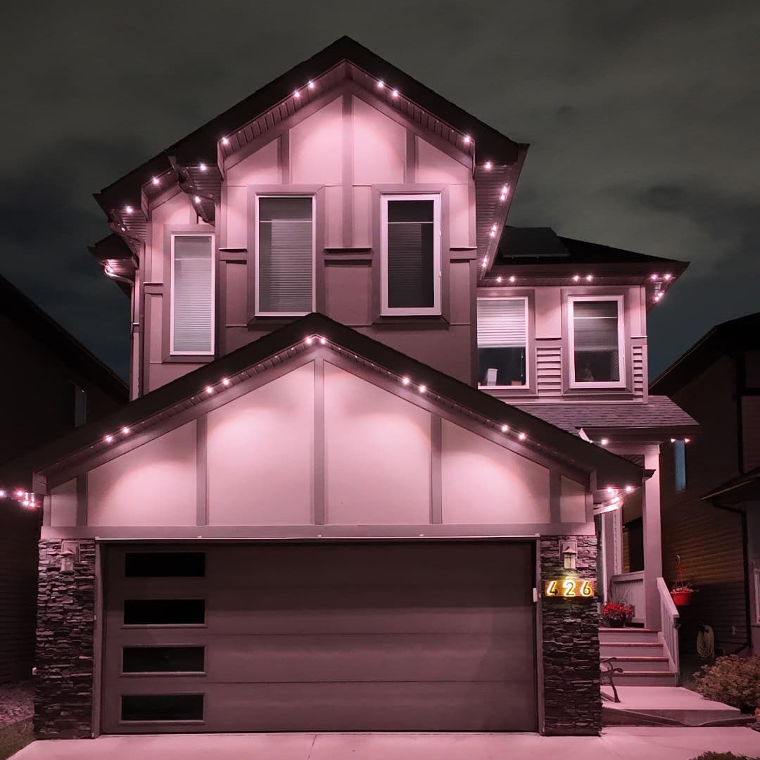 The same home at night with Lumen permanent lighting on in a warm colour